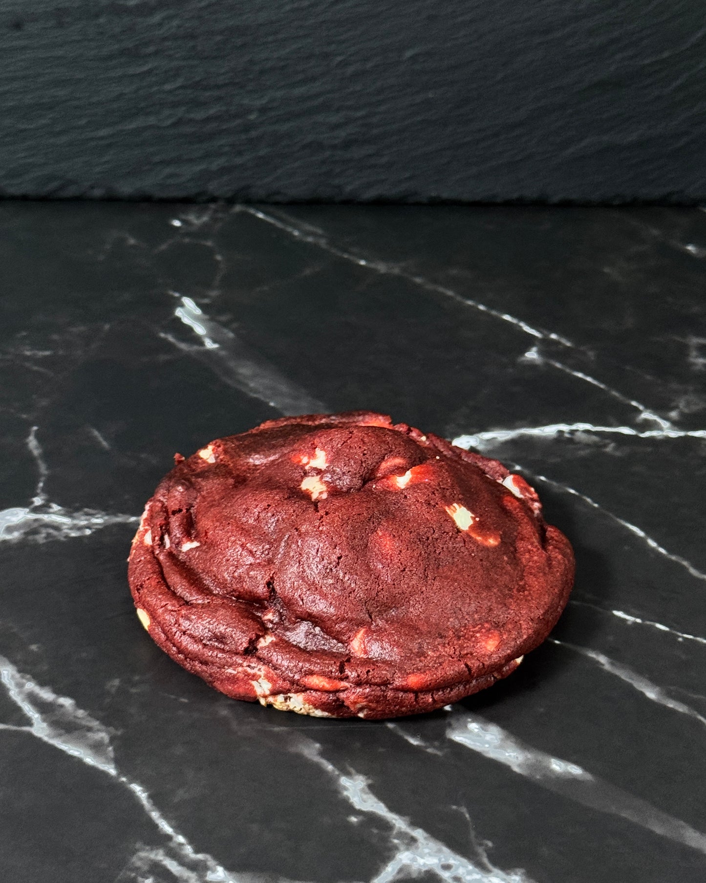Red Velvet Dream cookie made with white chocolate chips and cheesecake filing