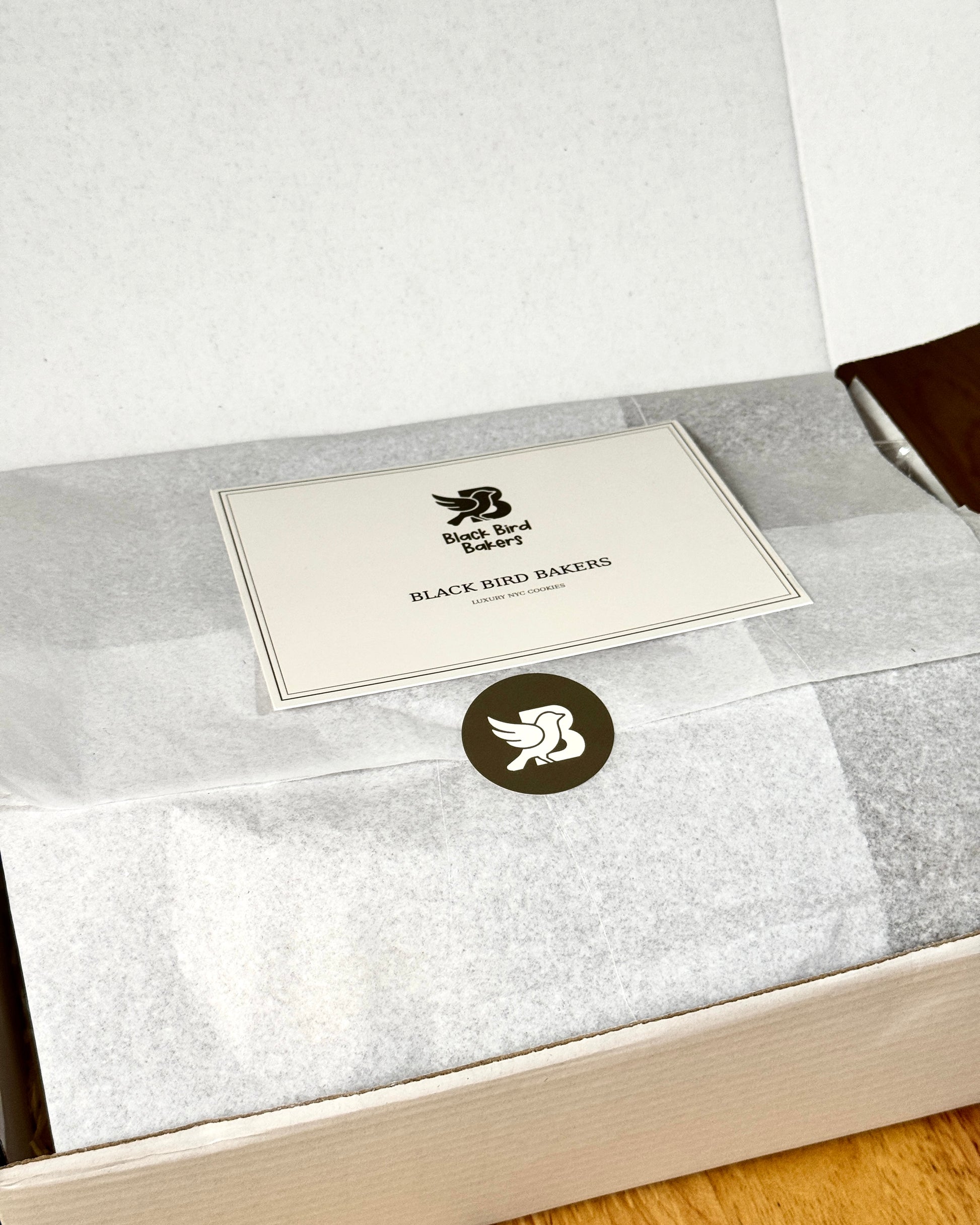 Black Bird Bakers cookie gift box wrapped with branded tissue paper