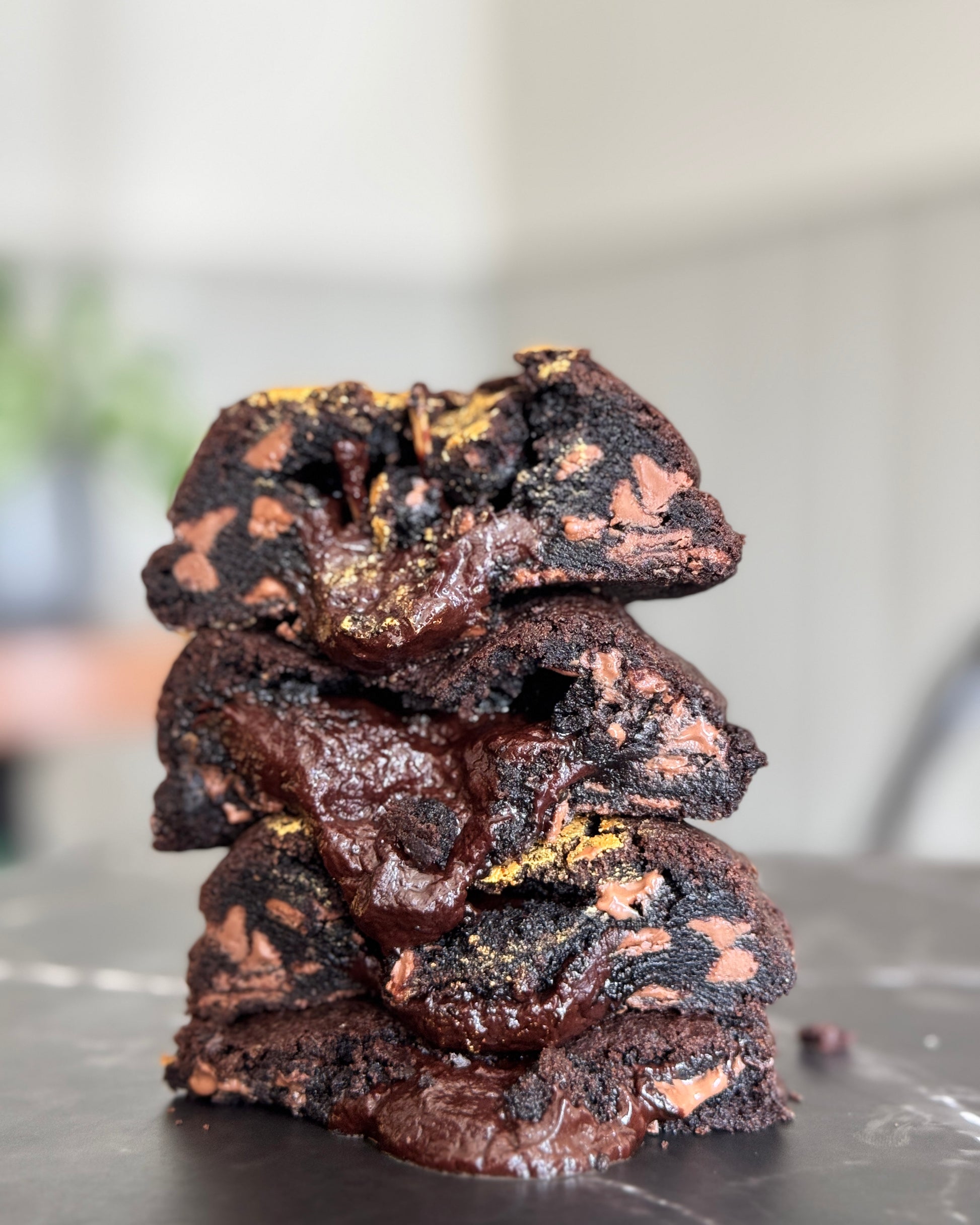 Double Trouble NYC cookie stacked on a table, loaded with Callebaut milk chocolate chunks and filled with a rich milk chocolate ganache