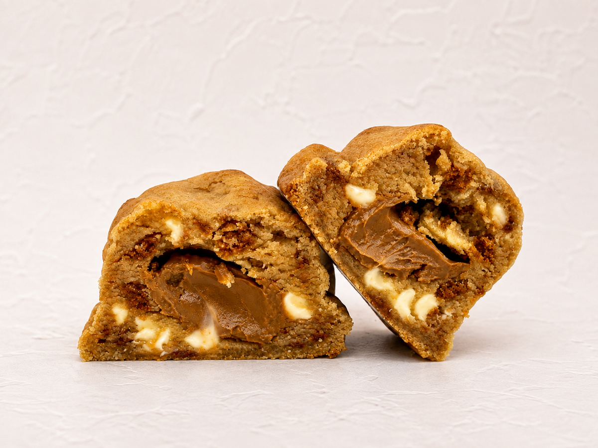 Biscoff Billionaire thick cookie cut open with Belgian white chocolate and a gooey Biscoff centre