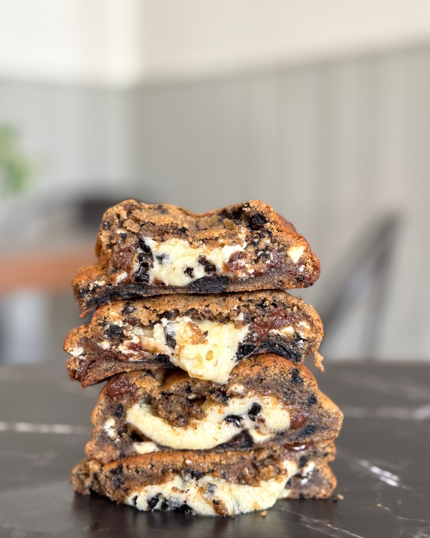 Cookie & cream NYC cookies stacked to show gooey white chocolate ganache centre and Oreo cookie chunks