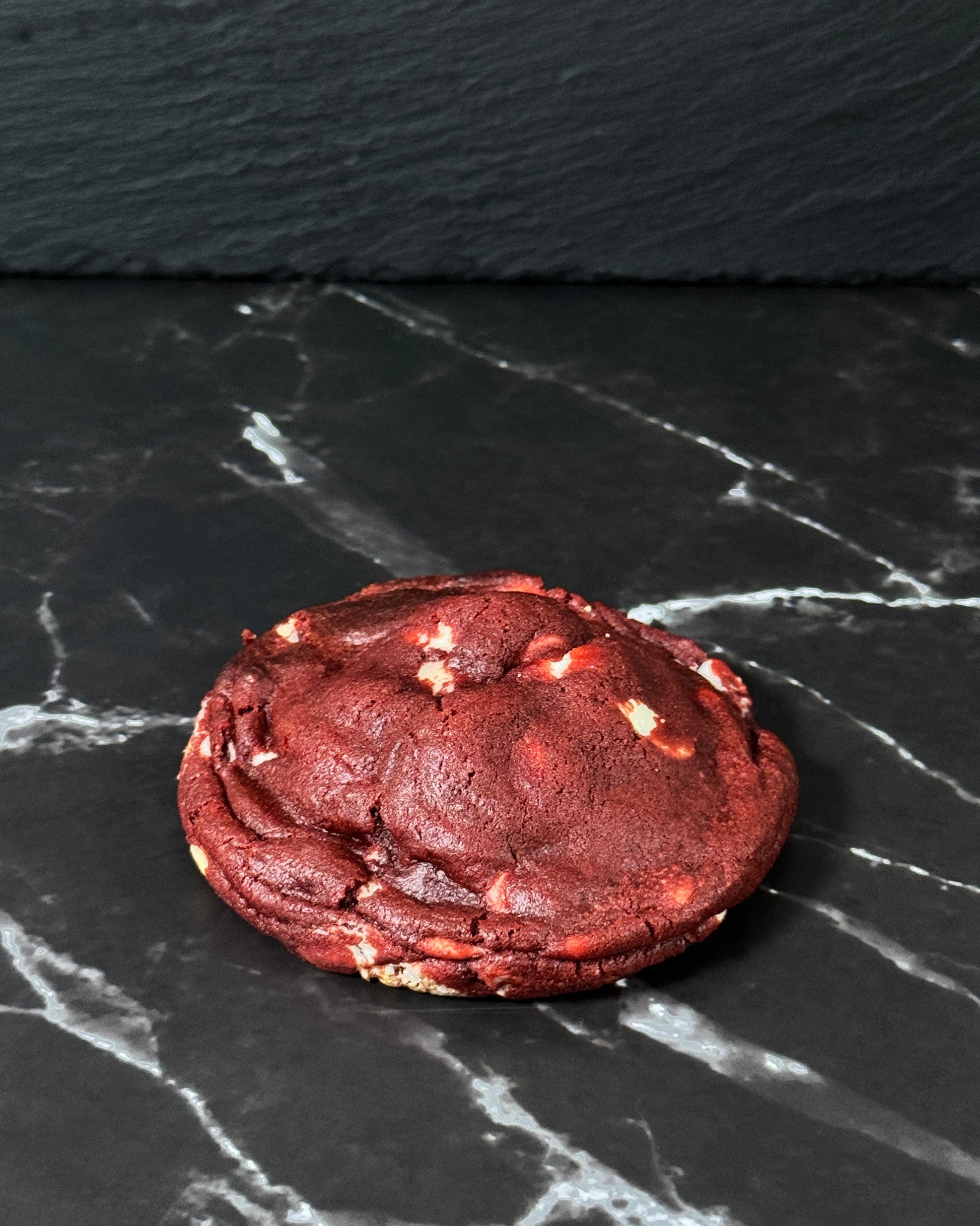 Red Velvet Dream cookie made with white chocolate chips and cheesecake filing